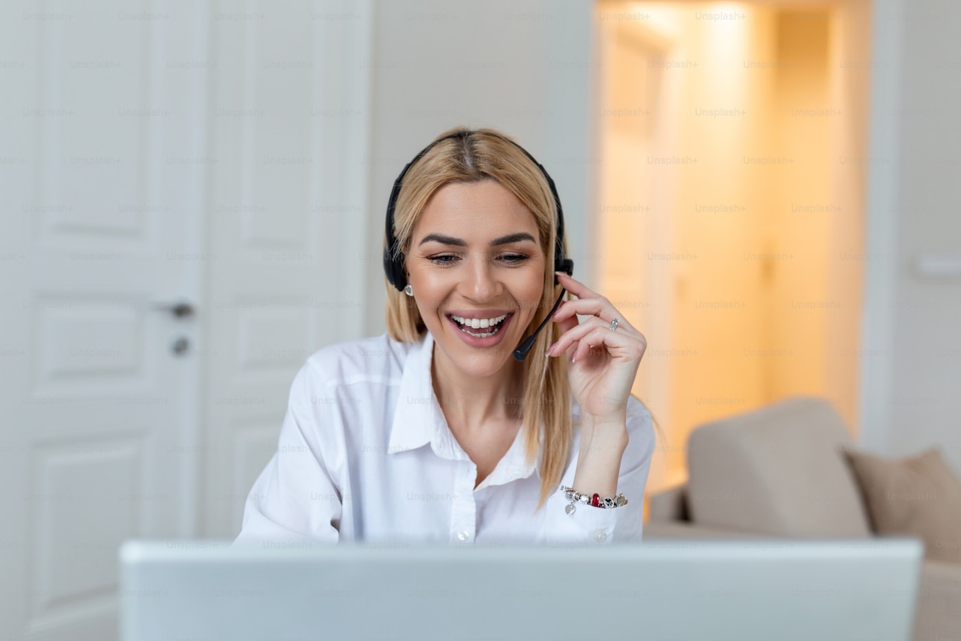 Persona trabajando con una computadora y un teléfono para atender clientes