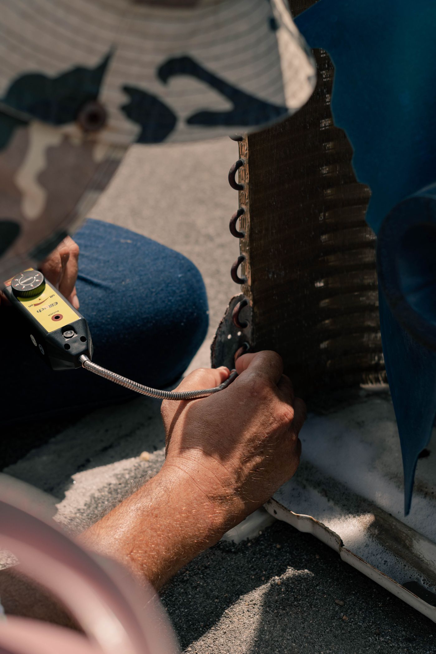 Técnico reparando una unidad de aire acondicionado con herramientas