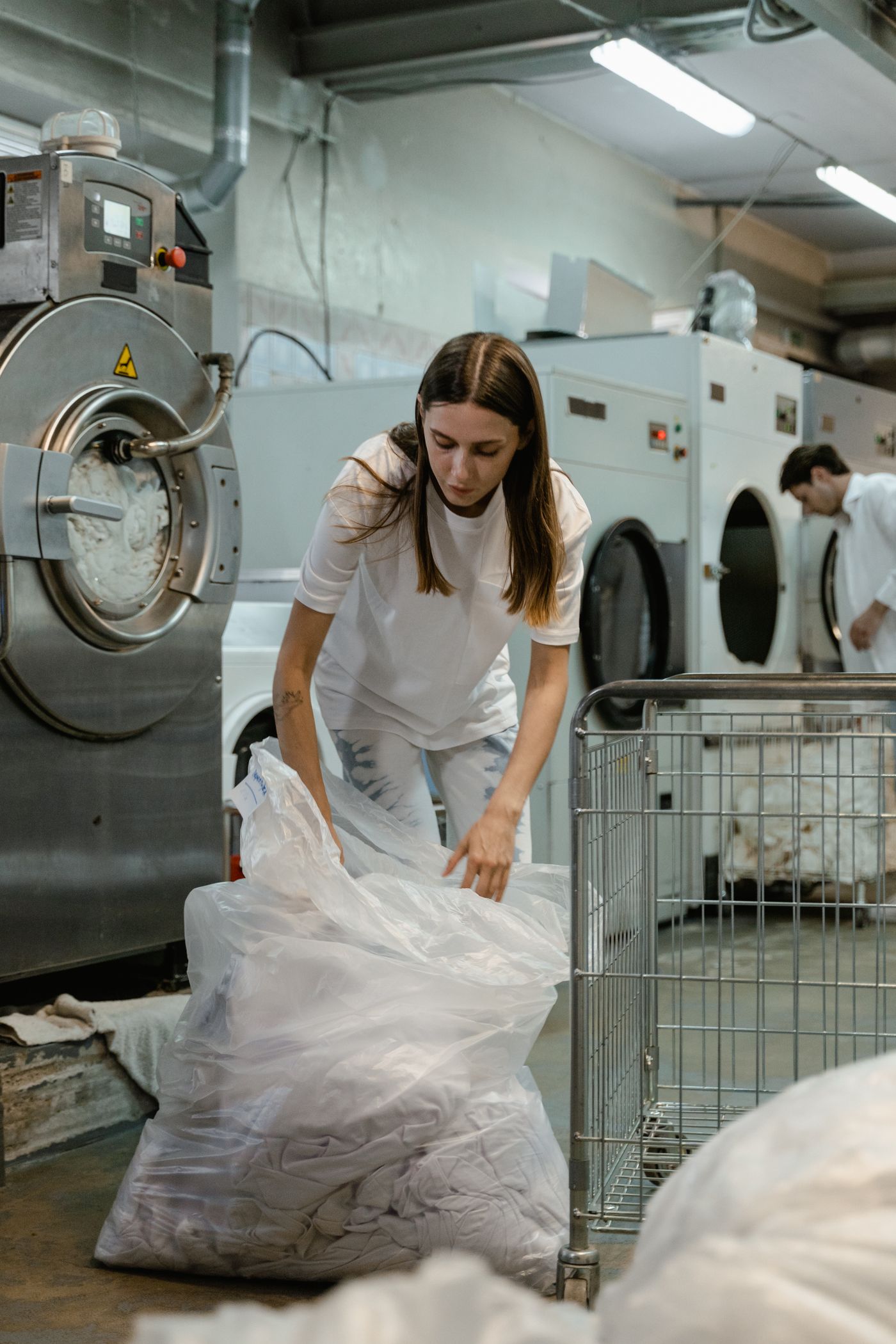 Trabajadora clasificando textiles en una lavandería comercial